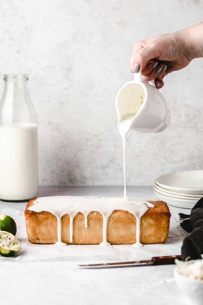 Pouring lime glaze over coconut lime cake.