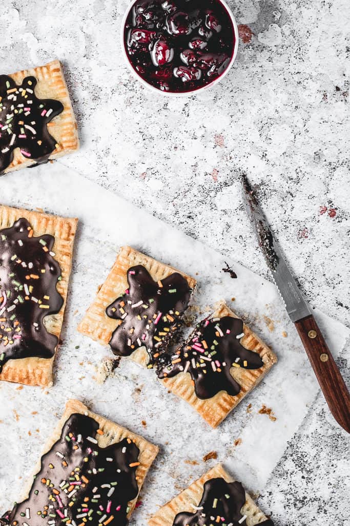 These Cherry Pop Tarts with sprinkled Chocolate glaze are a perfect snack. Sweet and tangy cherry filling, cloaked in flaky, all-butter pie crust and then topped with simple chocolate glaze - heavenly combination! Ooh, let's not forget sprinkles! ⎪www.anasbakingchronicles.com