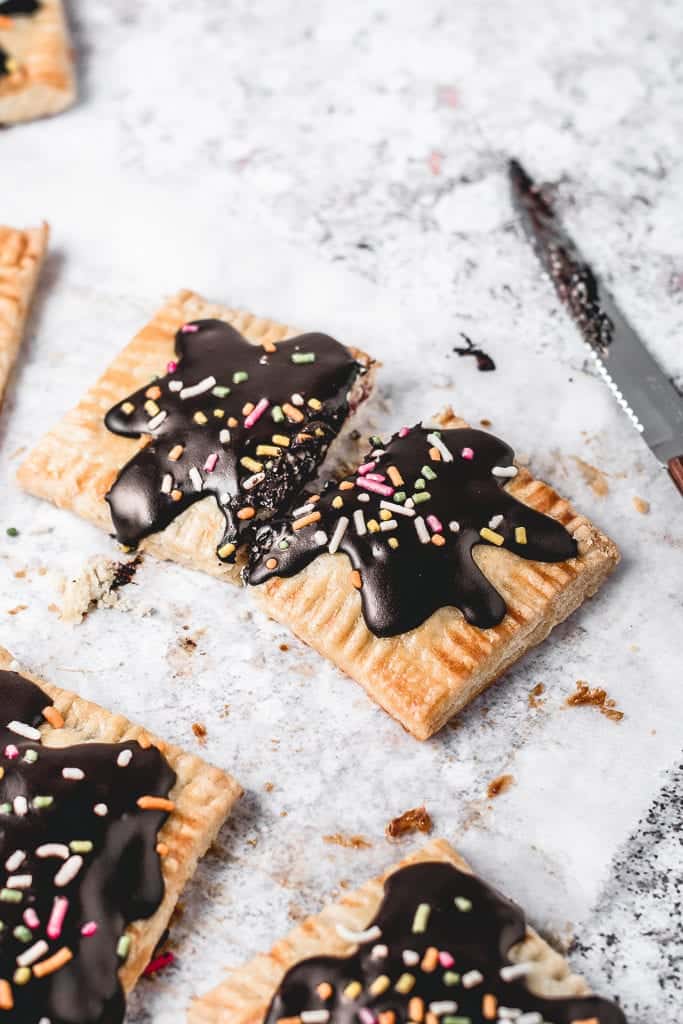 These Cherry Pop Tarts with sprinkled Chocolate glaze are a perfect snack. Sweet and tangy cherry filling, cloaked in flaky, all-butter pie crust and then topped with simple chocolate glaze - heavenly combination! Ooh, let's not forget sprinkles! ⎪www.anasbakingchronicles.com