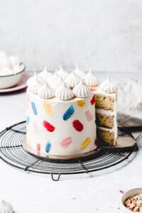 This Funfetti layer cake is perfect for birthdays, celebrations or just because! Soft and moist vanilla funfetti cake layers, paired with silky vanilla buttercream and filled with homemade strawberry jam. Learn how to make it from scratch, it's easy! www.anasbakingchronicles.com