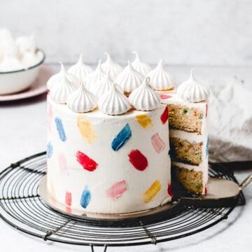 This Funfetti layer cake is perfect for birthdays, celebrations or just because! Soft and moist vanilla funfetti cake layers, paired with silky vanilla buttercream and filled with homemade strawberry jam. Learn how to make it from scratch, it's easy! www.anasbakingchronicles.com