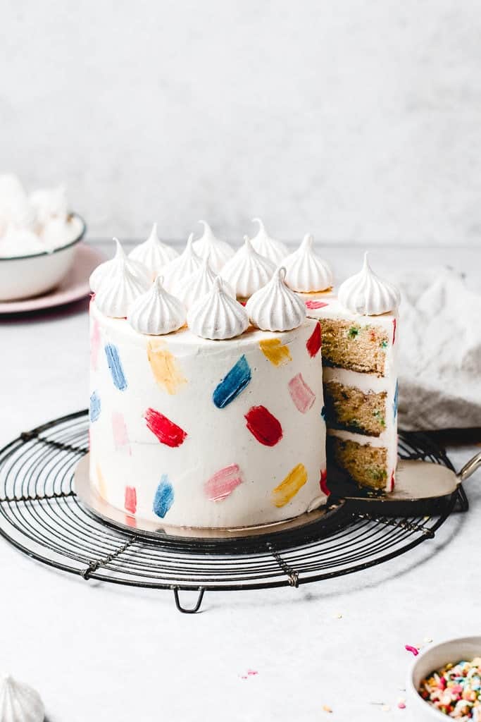 This Funfetti layer cake is perfect for birthdays, celebrations or just because! Soft and moist vanilla funfetti cake layers, paired with silky vanilla buttercream and filled with homemade strawberry jam. Learn how to make it from scratch, it's easy!  www.anasbakingchronicles.com