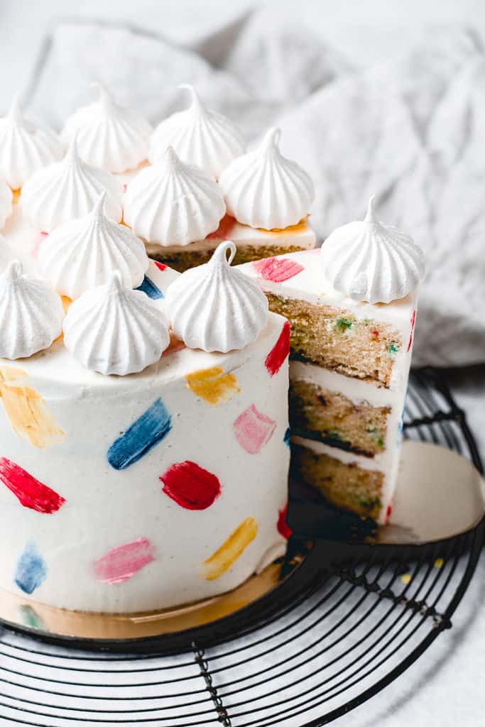 This Funfetti layer cake is perfect for birthdays, celebrations or just because! Soft and moist vanilla funfetti cake layers, paired with silky vanilla buttercream and filled with homemade strawberry jam. Learn how to make it from scratch, it's easy!  www.anasbakingchronicles.com