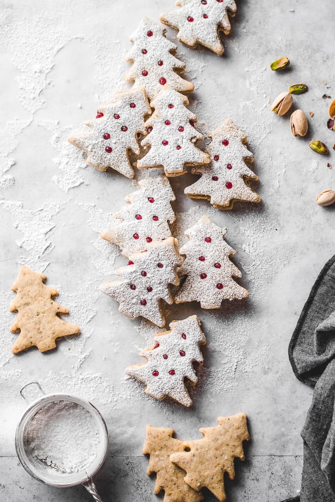 These lovely Pistachio Cranberry Linzer Christmas trees are going to be the star of your holiday table! With their festive looks and delicious flavour, they will win everyone's heart! ⎪www.anasbakingchronicles.com

#christmascookies
#christmasbaking
#linzercookies