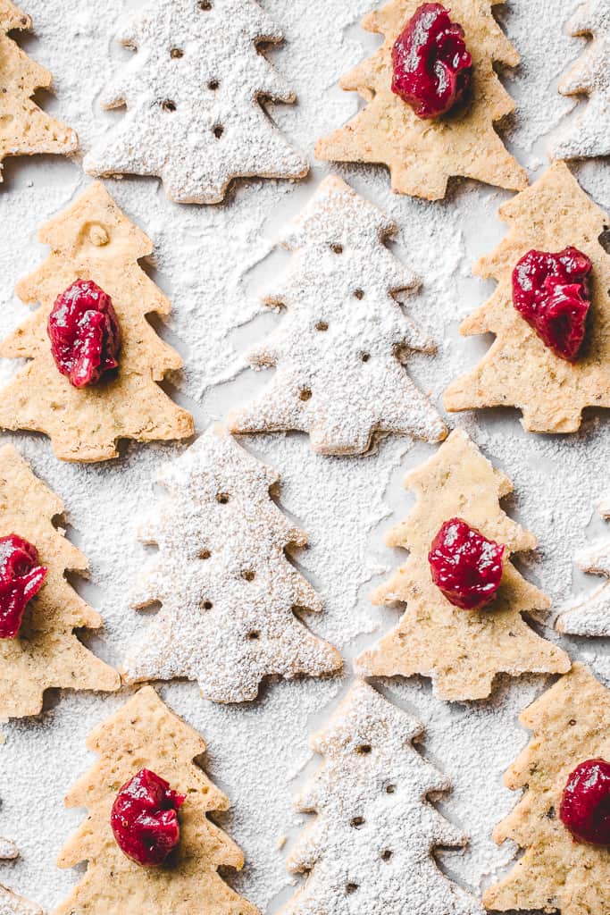 These lovely Pistachio Cranberry Linzer Christmas trees are going to be the star of your holiday table! With their festive looks and delicious flavour, they will win everyone's heart! ⎪www.anasbakingchronicles.com

#christmascookies
#christmasbaking
#linzercookies