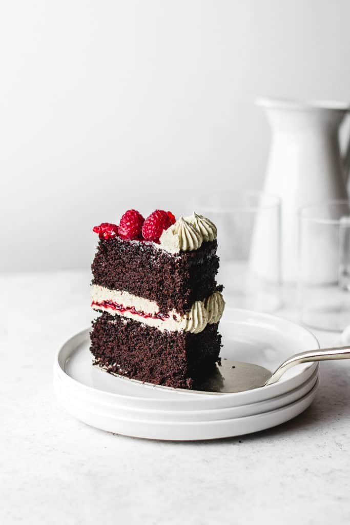 Rich and moist chocolate cake, paired with silky pistachio buttercream and homemade raspberry jam. So festive and easy to make! ⎪www.anasbakingchronicles.com