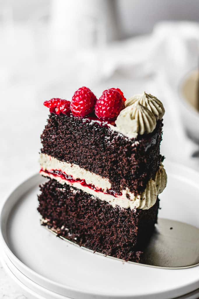 Rich and moist chocolate cake, paired with silky pistachio buttercream and homemade raspberry jam. So festive and easy to make! ⎪www.anasbakingchronicles.com