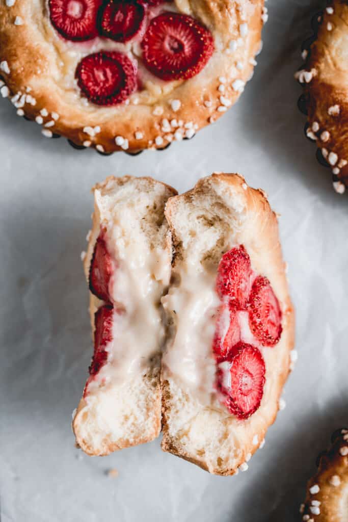 Brioche tarts made with tonka bean pastry cream and strawberries, cut in half to see the fluffy interior.