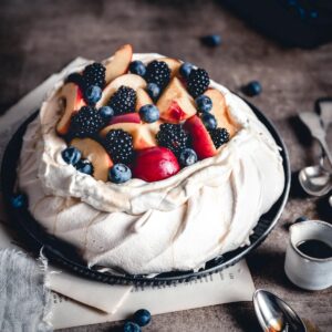 Peach Pavlova with Berries served whole on a plate.