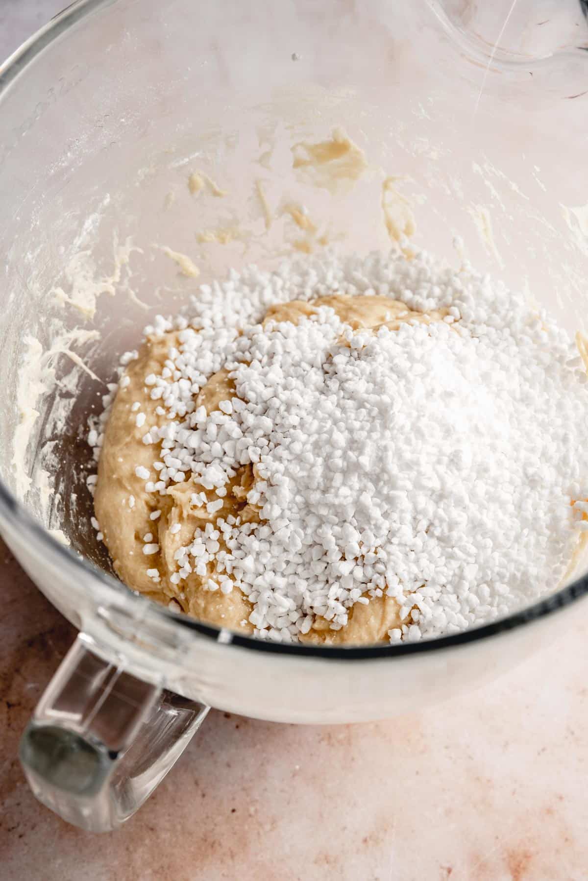 A bowl with the dough and added pearl sugar.