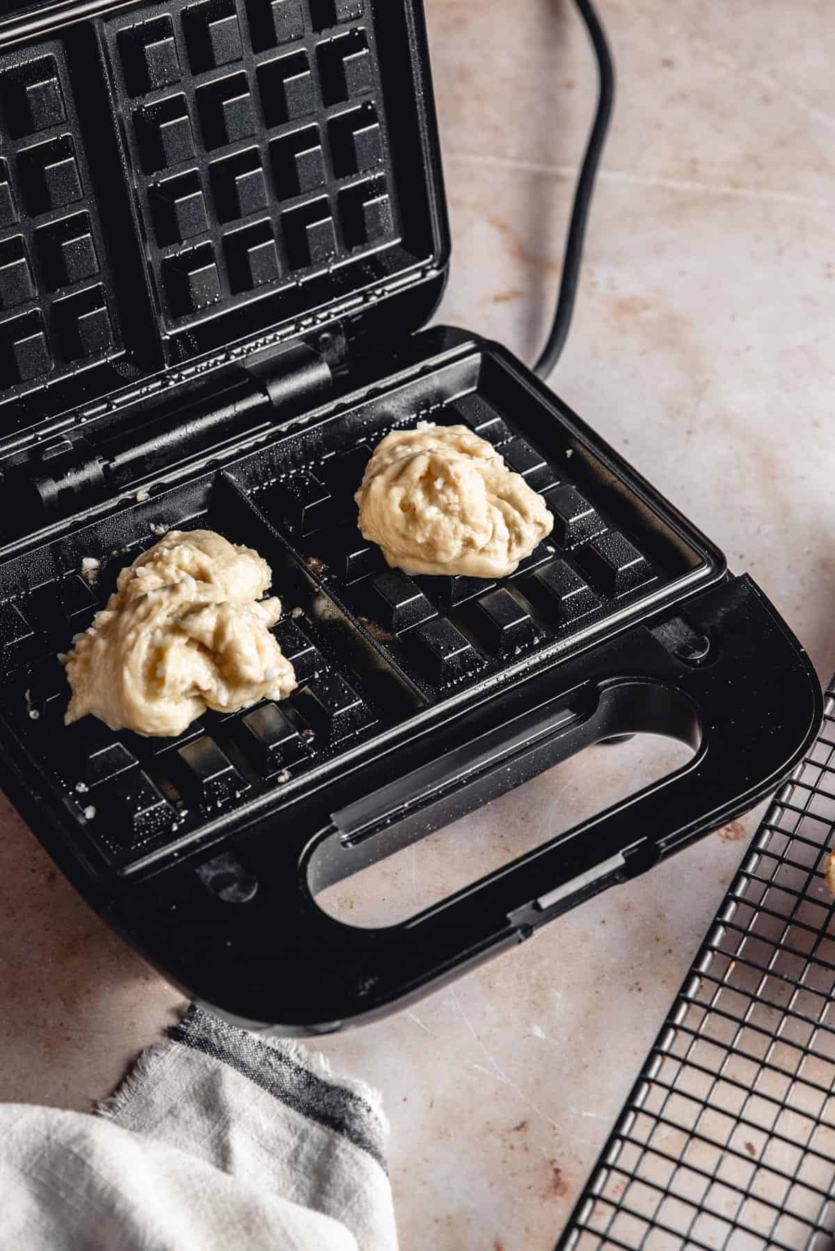 Balls of dough in a waffle iron.