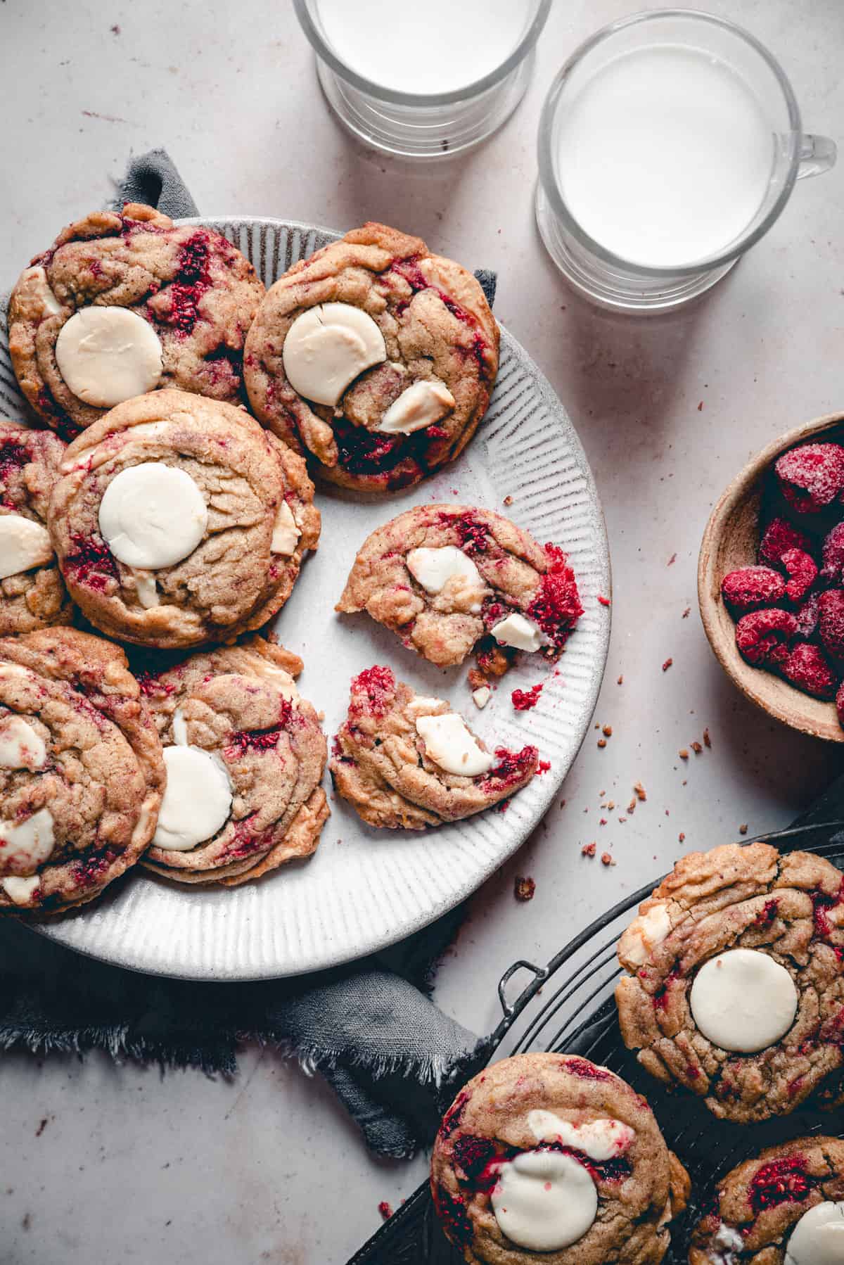 Raspberry White Chocolate Cookies served on a plate with glasses of milk