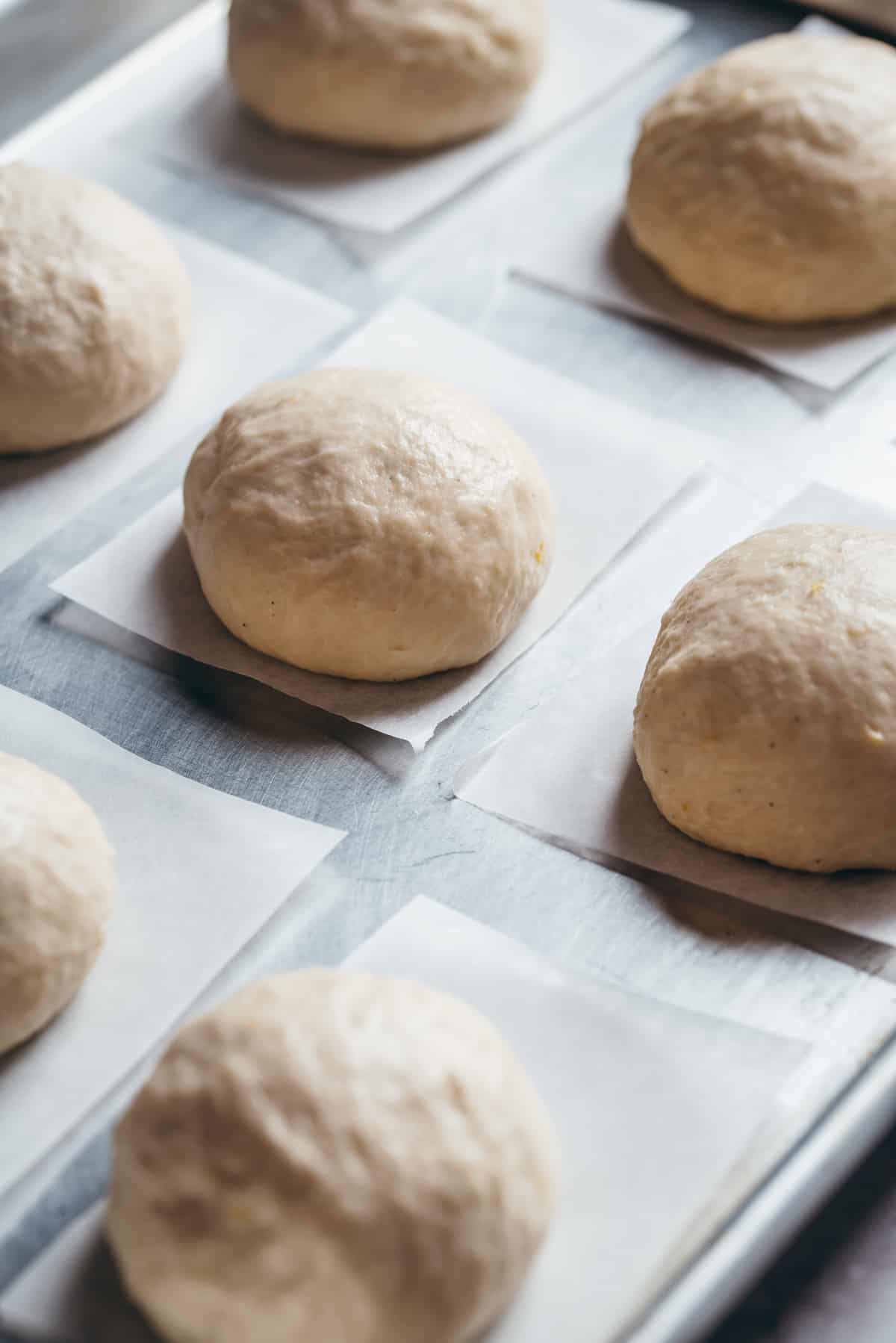 Balls of dough on a tray before last proof and frying