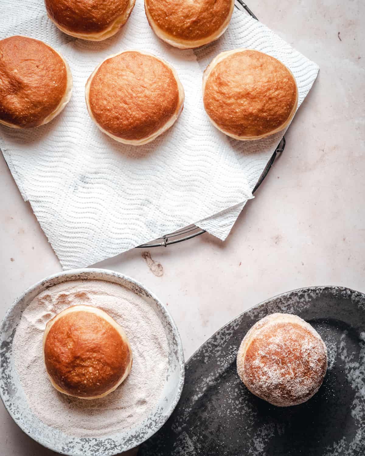 Coating fried doughnuts in cinnamon sugar