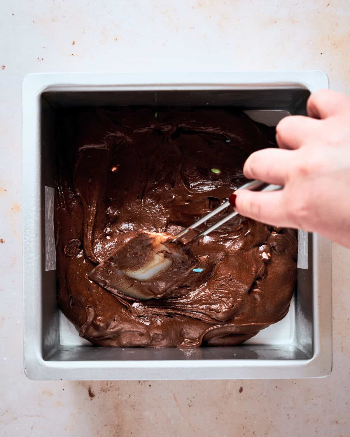 Mini Egg Brownie batter being spread in the tin.